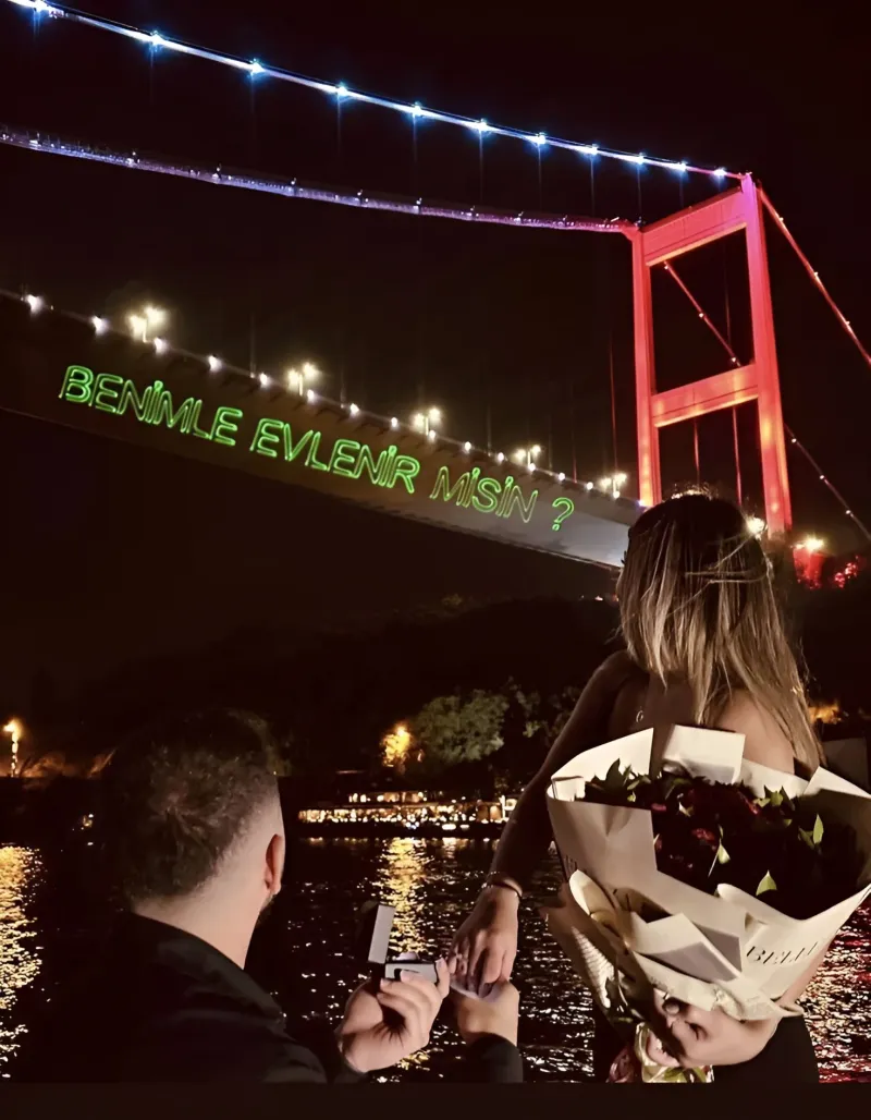 A laser projection reading 'Will you marry me?' on the Bosphorus bridge