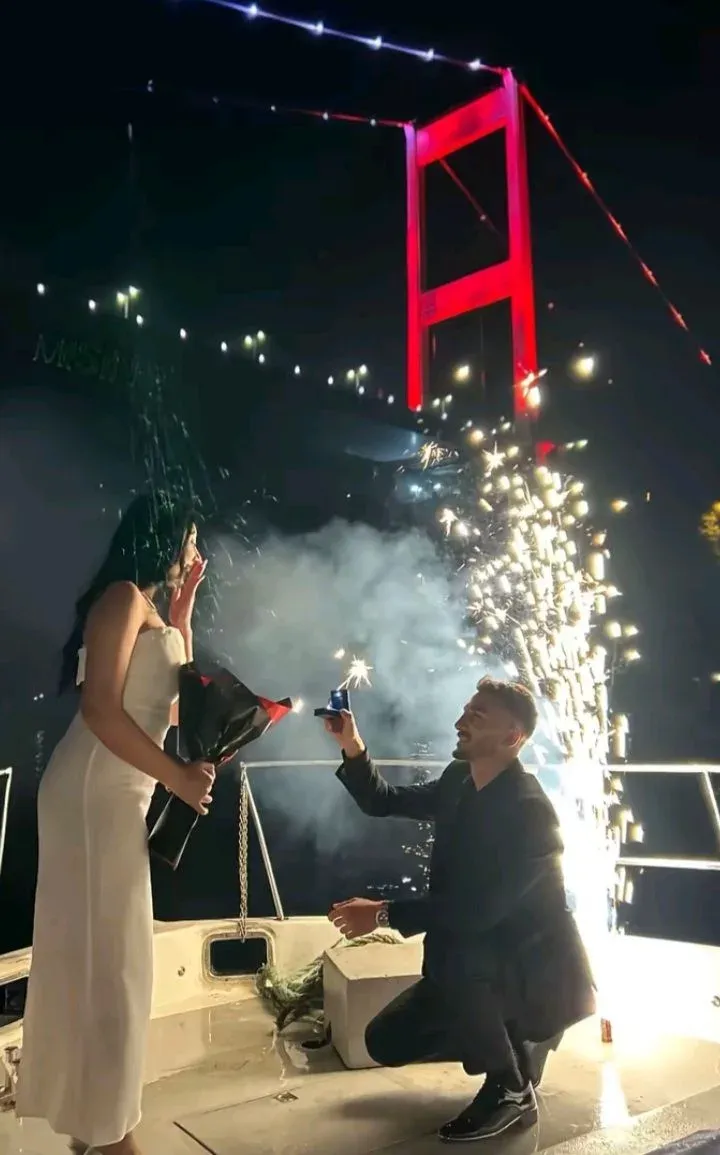 A night proposal with a cold-spark fountain, the Bosphorus bridge behind